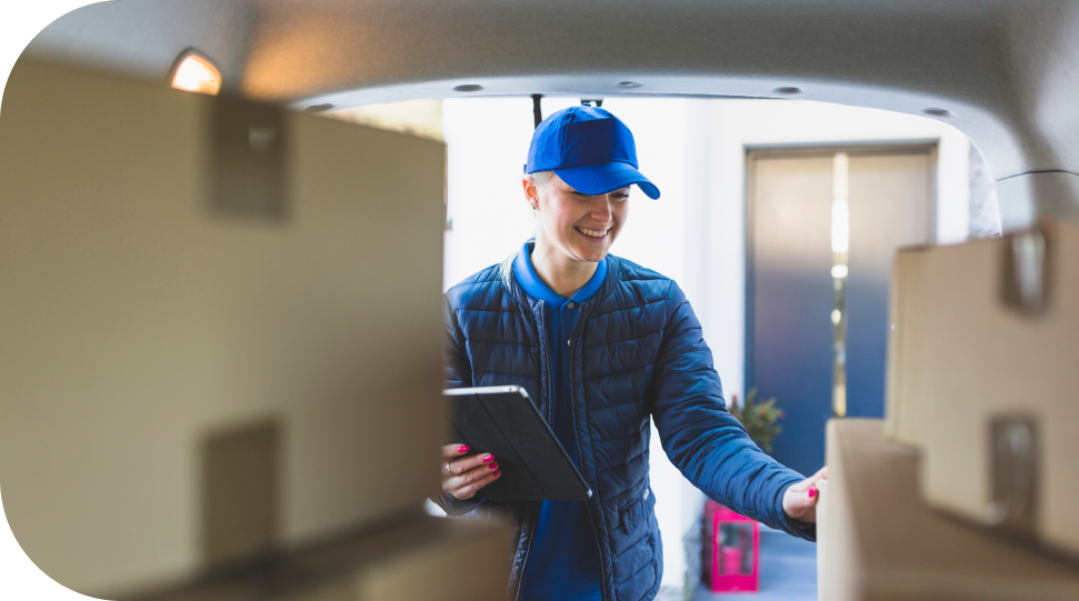 Imagem de uma mulher pegando uma caixa segurando um tablet