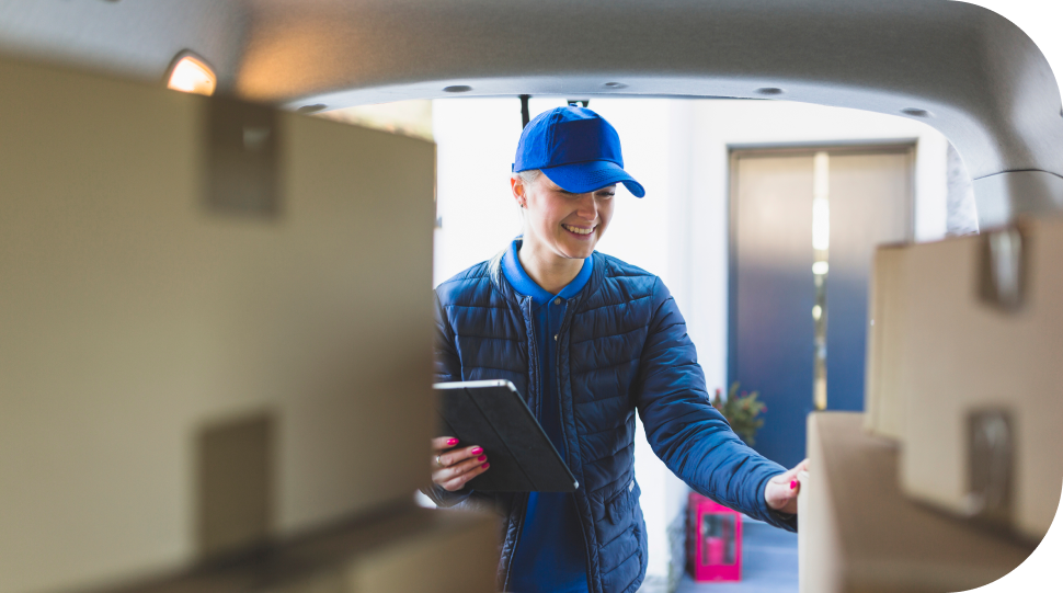 Imagem de uma mulher pegando uma caixa segurando um tablet