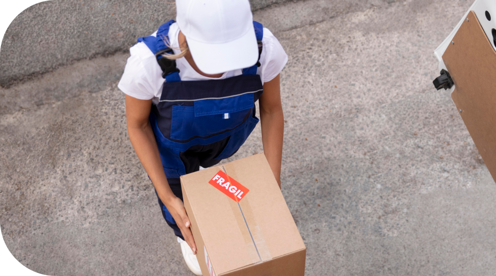 Imagem de uma entregadora segurando uma caixa escrito fragil
